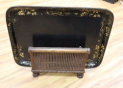 A large papier mache gilt-decorated tray and a 1930's carved oak Canterbury, with double rattan