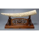A Japanese ivory 'Seven immortals' tusk carving, early 20th century, wood stand, signed, 44cm