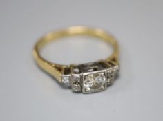 An early 20th century '18ct and plat' diamond ring, the square set central stone flanked each side