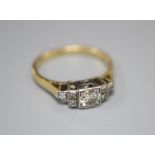 An early 20th century '18ct and plat' diamond ring, the square set central stone flanked each side