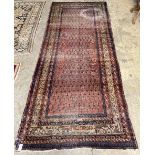 A Shirvan red ground carpet, 330 x 134cm