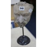 A life mask of a gentleman on stand