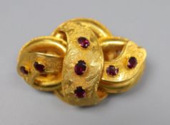 A Victorian yellow metal and seven stone garnet set scroll brooch, 47mm, gross 13.1 grams.CONDITION: