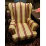A 1920's wing armchair upholstered in striped fabric, width 80cm, depth 74cm, height 100cm