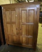 A carved and panelled oak and beech double wardrobe, width 120cm, depth 50cm, height 199cm