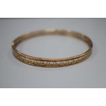 A 9ct bangle with pierced Greek key border, 12.8 grams.