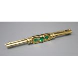 A yellow metal and three stone emerald set tie pin, 52mm, gross 5.4 grams.