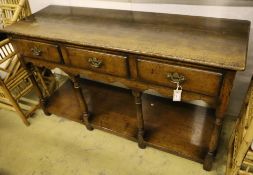 A George III style oak dresser base, fitted three drawers and undertier, width 138cm, depth 46cm,