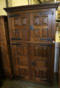 A French oak rustic-style panelled cupboard fitted upper and lower pairs of doors, width 122cm,