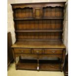 A small Georgian style reproduction oak dresser, having shelved boarded back, shaped apron and pot