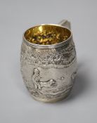 A George III silver barrel shaped christening mug, embossed with figures at play in woodland