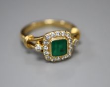 A modern 18ct gold, emerald and diamond cluster ring, size N, gross 6.6 grams.CONDITION: Three of