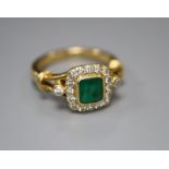 A modern 18ct gold, emerald and diamond cluster ring, size N, gross 6.6 grams.CONDITION: Three of