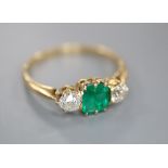 A yellow metal, emerald and diamond three stone ring, size Q, gross 2.3 grams.CONDITION: The emerald