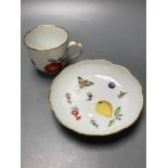 A Meissen cup and saucer, factory seconds, decorated with fruit and butterflies and lined with