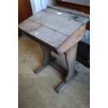 An early 20th century oak school desk, width 56cmCONDITION: Rather faded with a damp stain to the