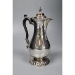A George V silver baluster hot water pot, with ebonised handle, Goldsmiths & Silversmiths Co Ltd,