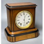 A walnut cased and ebonised mantel clock retailed by JW Benson, French movement striking on a