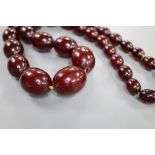 A single strand graduated simulated cherry amber oval bead necklace, 61cm, gross weight 99 grams.