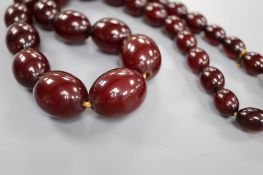 A single strand graduated simulated cherry amber oval bead necklace, 61cm, gross weight 99 grams.