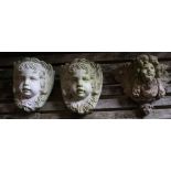 Three reconstituted stone cherub garden wall appliques, tallest 32cm