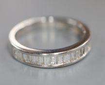 A modern 750 white metal and channel set twenty stone diamond half eternity ring, size O, gross 3.