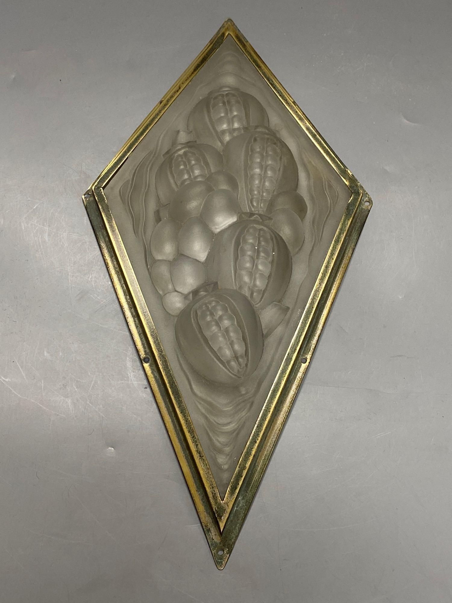 A pressed, frosted glass lozenge shape panel, within brass frame, height 35cmCONDITION: Good
