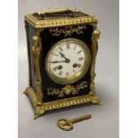 A French ebonised mantel clock with cast brass mounts, 9cm convex enamel dial, bell striking