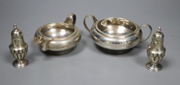 A George V silver sugar bowl and cream jug, London 1935 and a pair of Edwardian silver salt and