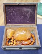 An amber necklace(a.f.) gross 85 grams, four assorted amber pebbles, 528 grams, a carved amber