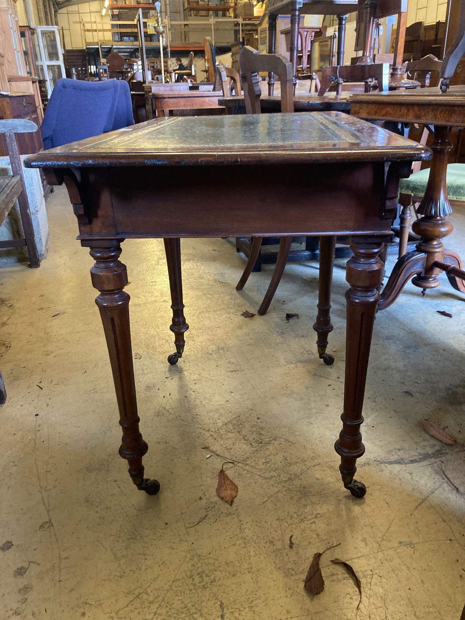 A late Victorian mahogany writing table, with leather lined top and ceramic castors, width - Image 4 of 4