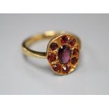 An 18ct and nine stone garnet oval cluster ring, size N, gross 4.4 grams.CONDITION: Probably been