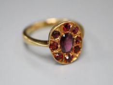 An 18ct and nine stone garnet oval cluster ring, size N, gross 4.4 grams.CONDITION: Probably been