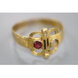 An antique reeded yellow metal and two stone set scroll ring, (stone missing and other stone