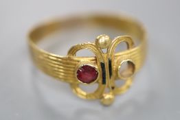 An antique reeded yellow metal and two stone set scroll ring, (stone missing and other stone