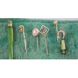 Five assorted Edwardian yellow metal and gem set stick pins, including 'pegasus' cameo and ruby,