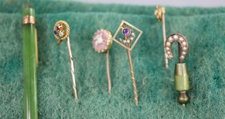 Five assorted Edwardian yellow metal and gem set stick pins, including 'pegasus' cameo and ruby,