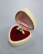 An 18ct and diamond cluster dress ring, in a raised setting, size Q/R, gross 5.9 grams.CONDITION: