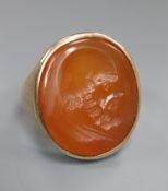 A late 19th century yellow metal and oval carnelian intaglio ring, carved with the head of a