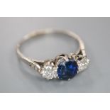 A white metal, sapphire and diamond three stone ring, with diamond chip set shoulders, size Q, gross