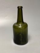 An early 18th century dark green glass wine bottle with a "kick in" based, 23cmCONDITION: Good