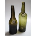 Two 19th century French green glass wine and spirit bottles, one with an armorial seal, the other