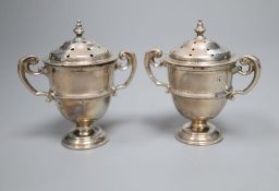 A cased pair of late Victorian small silver trophy shaped pepper pots, Horace Woodward & Co, London,