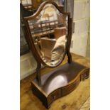 A shield-shaped swing frame mahogany toilet mirror, cross-banded and line-inlaid, the serpentine-