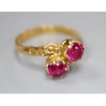 A yellow metal and two stone synthetic? ruby set crossover ring, size M/N, gross 2.3 grams.