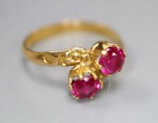 A yellow metal and two stone synthetic? ruby set crossover ring, size M/N, gross 2.3 grams.