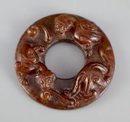 A Chinese brown jade bi disc, carved in relief with chilong, 5cm diameter