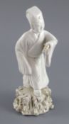 A Chinese blanc de chine figure of an official holding a scroll, Qing dynasty, on a rockwork base,