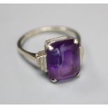 An Art Deco style 9ct white metal and emerald cut amethyst set dress ring, with stepped shoulders,