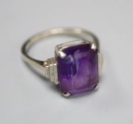 An Art Deco style 9ct white metal and emerald cut amethyst set dress ring, with stepped shoulders,